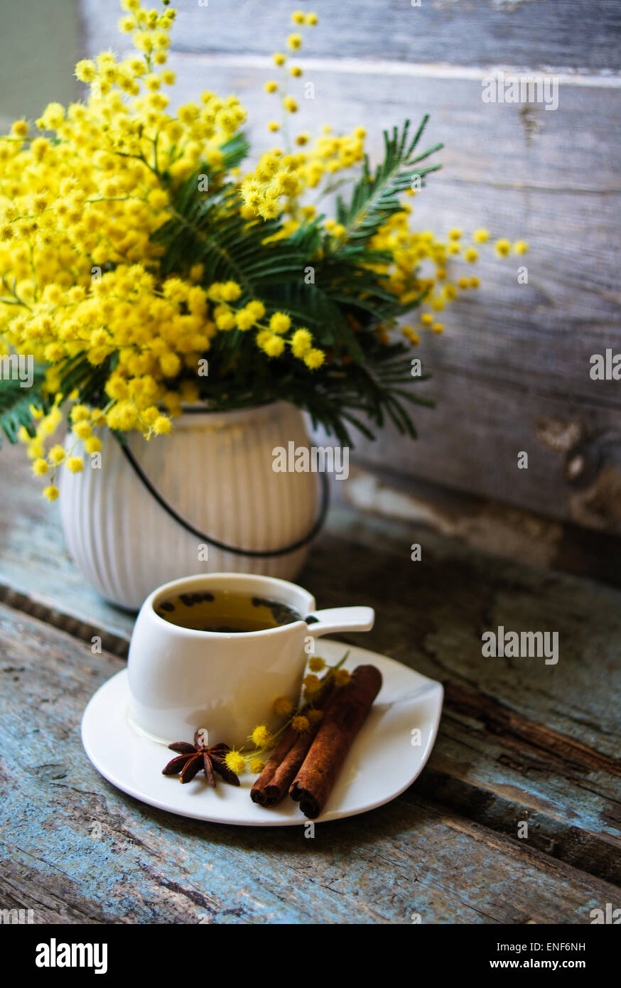 Glass Cup With Tea And Blooming Yellow Mimosa With Good Morning