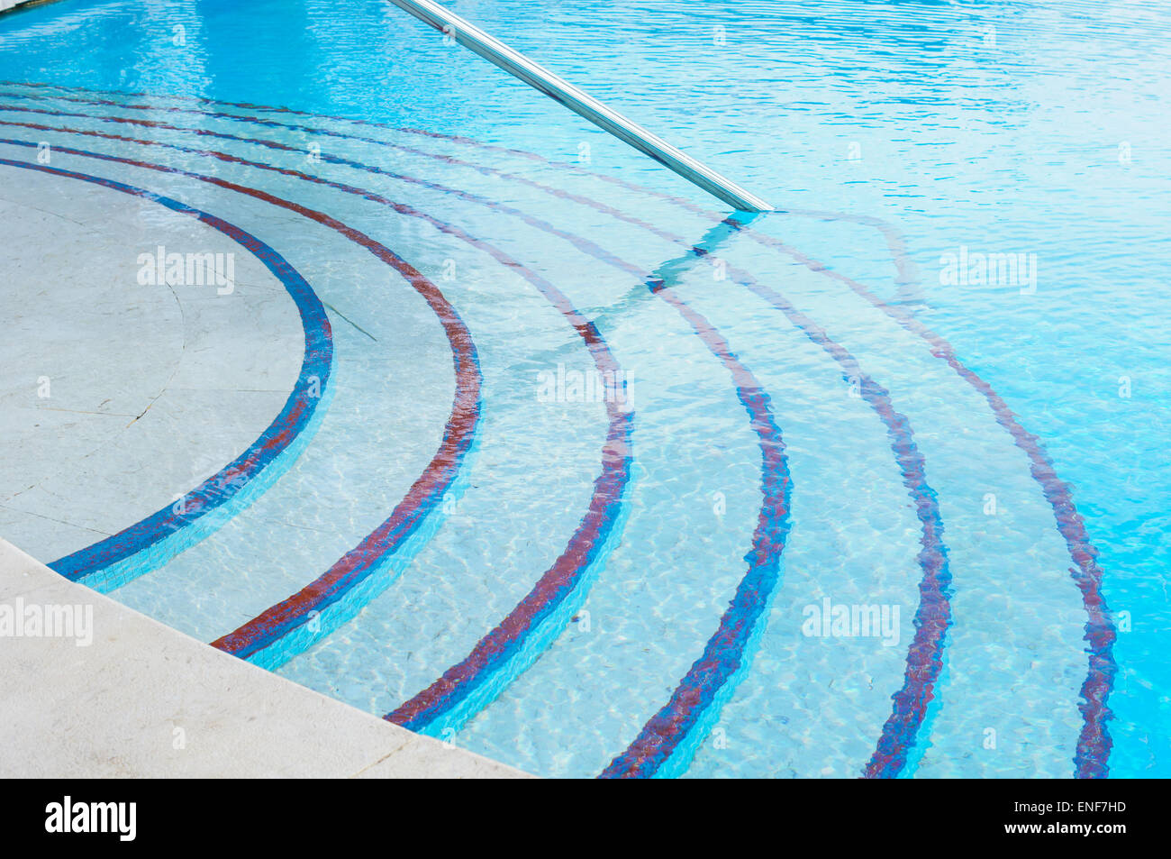 blue swimming pool with teak wood flooring stripes summer vacation