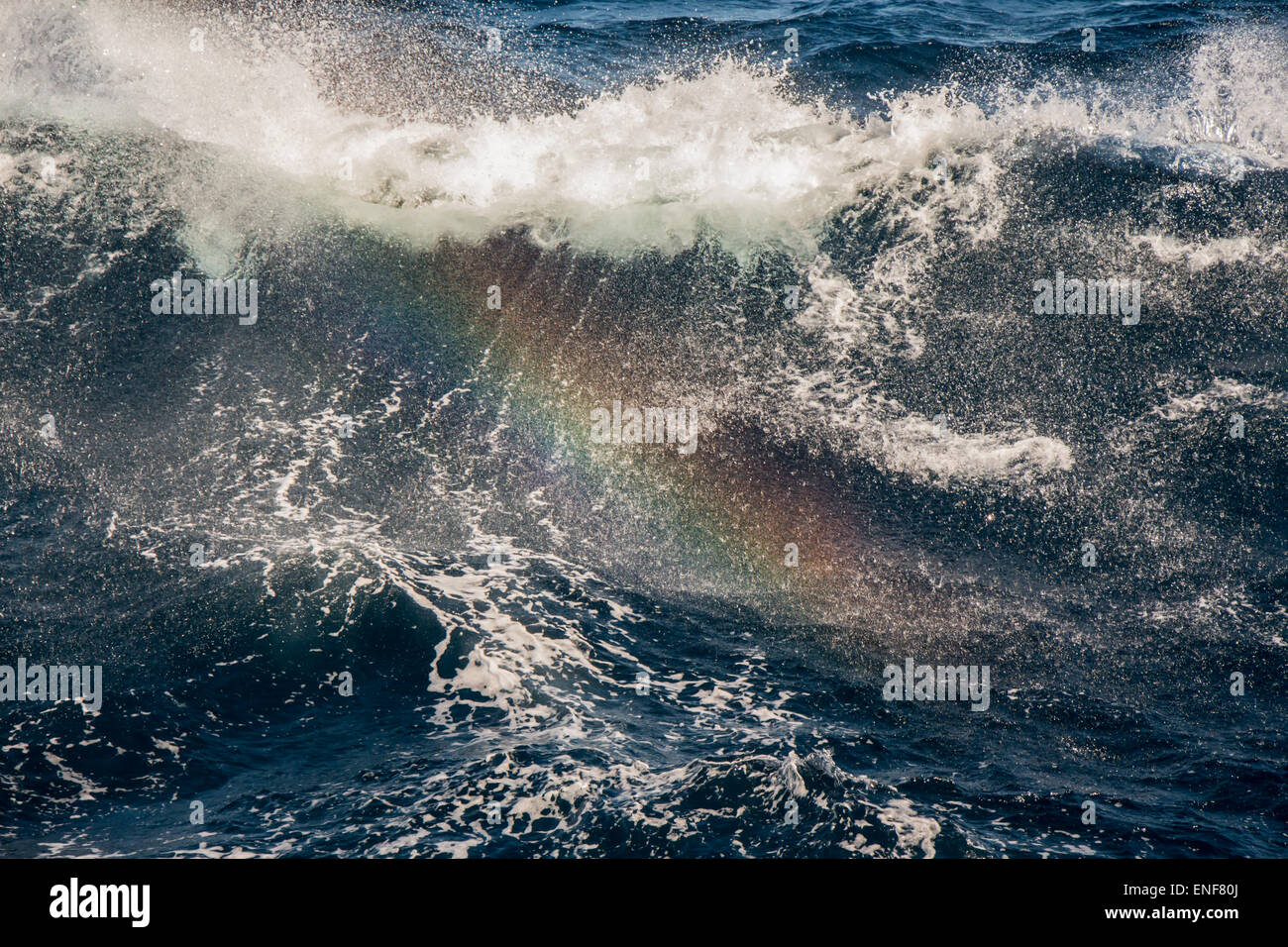 Splashes of sea water with rainbow occurrence. Stock Photo