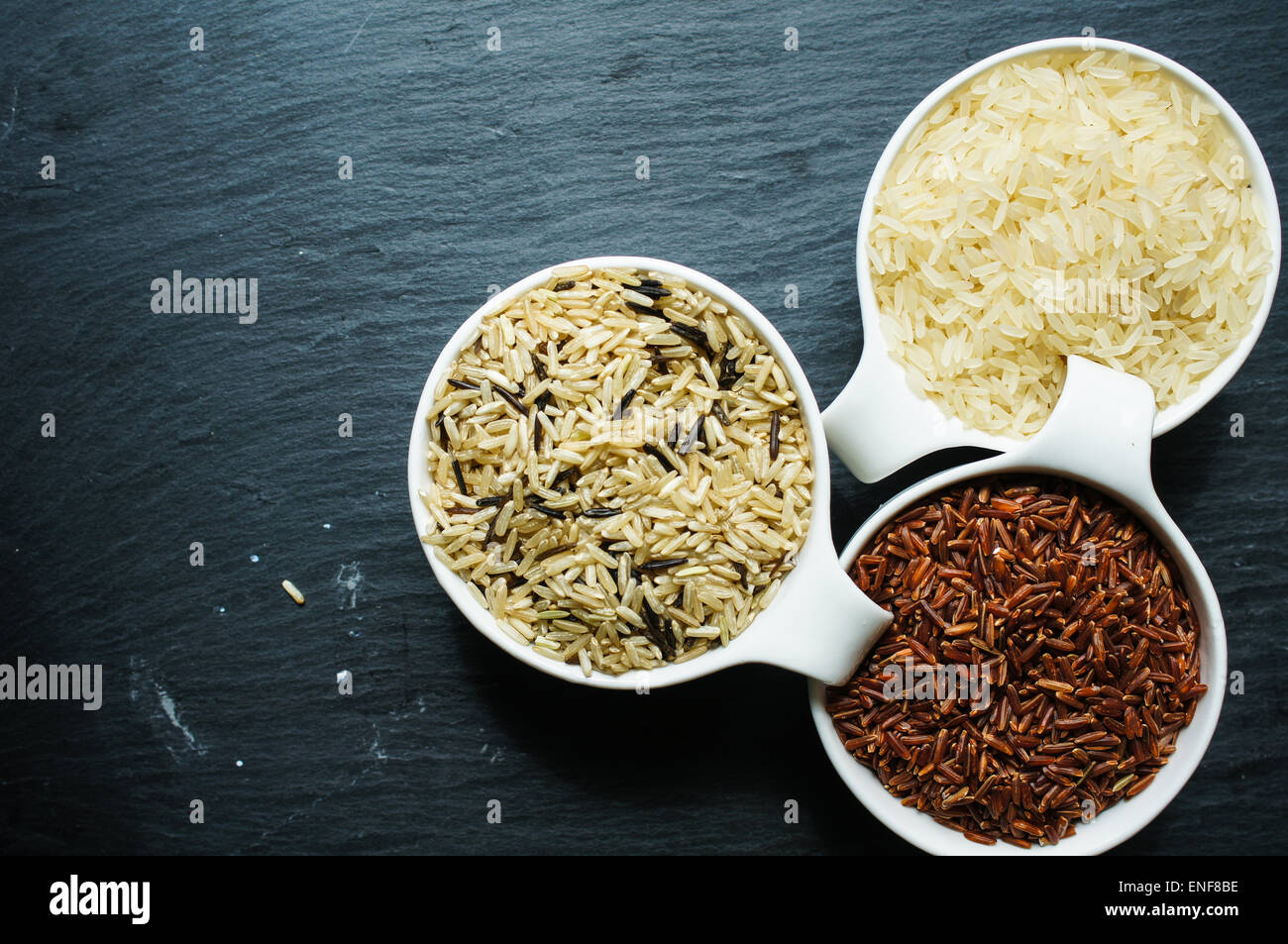 Different kinds of rice in the pots on the rustic table Stock Photo - Alamy