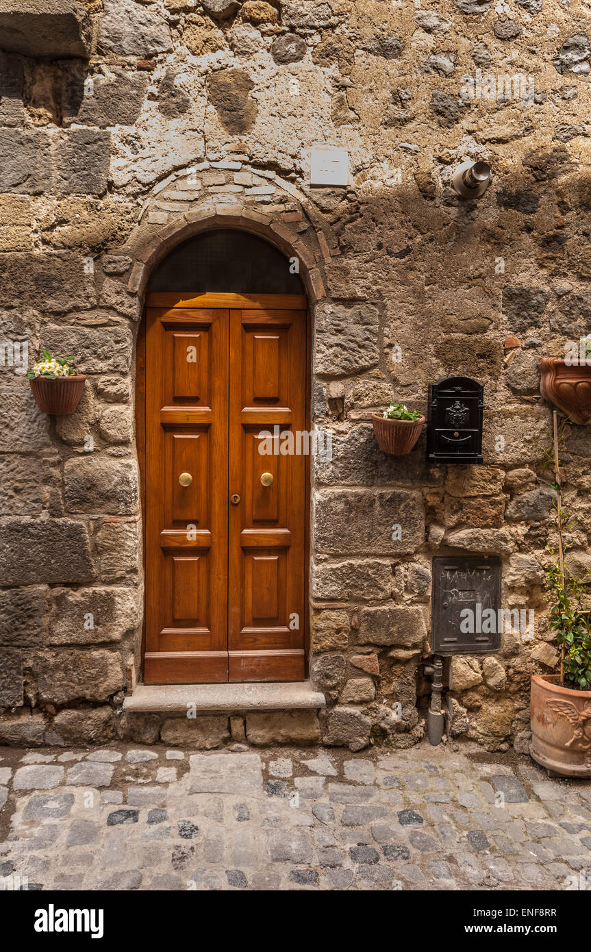 Wooden door entrance of stone building in Bolsena, Italy Stock Photo