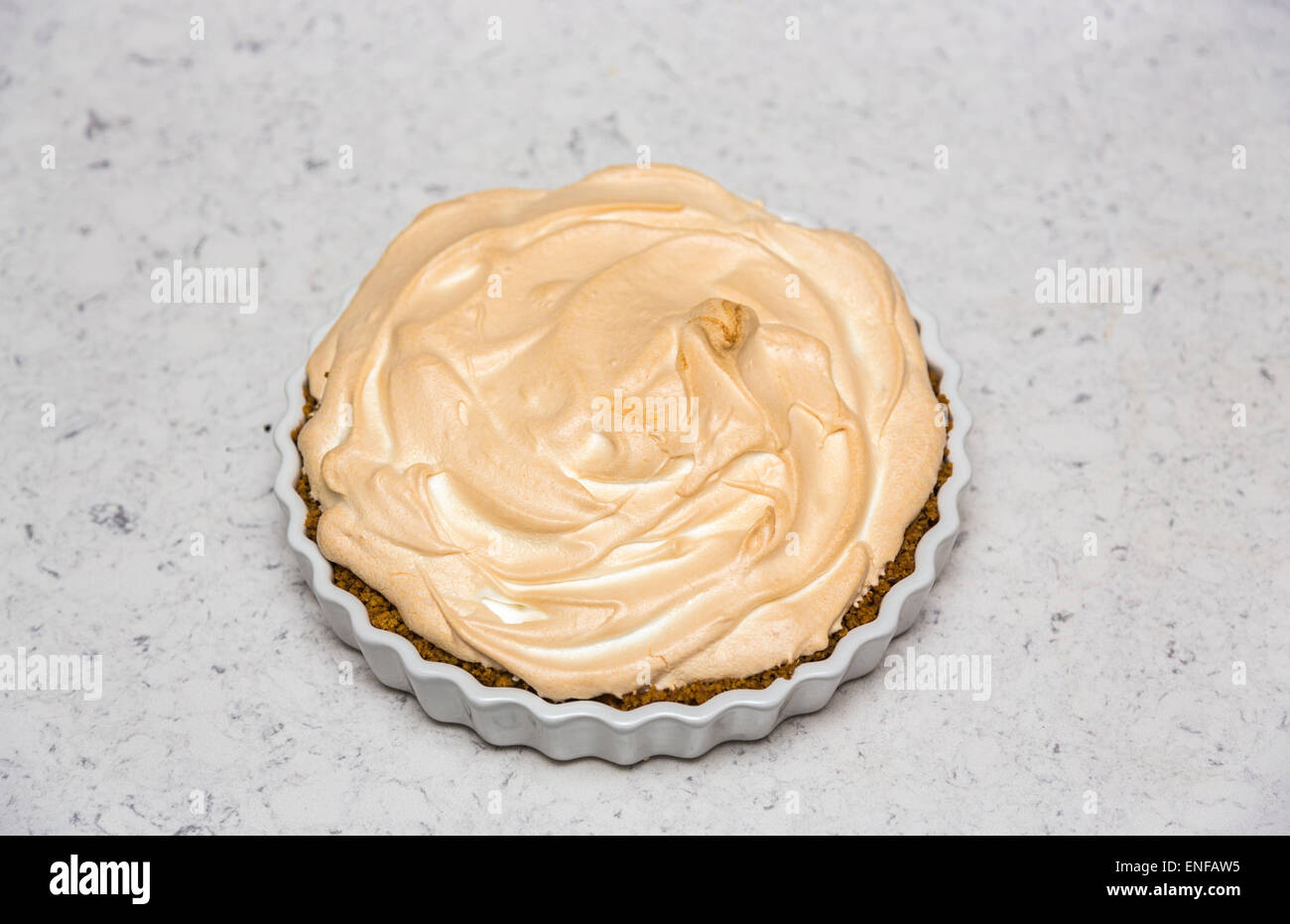 Fresh, delicious home cooked lemon meringue pie in a round white scalloped pie dish Stock Photo