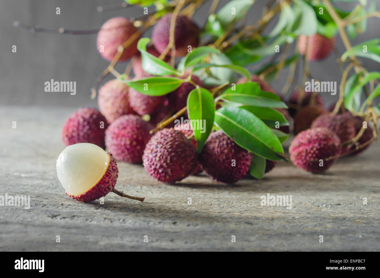 Lychee with leaves on a wooden table Stock Photo