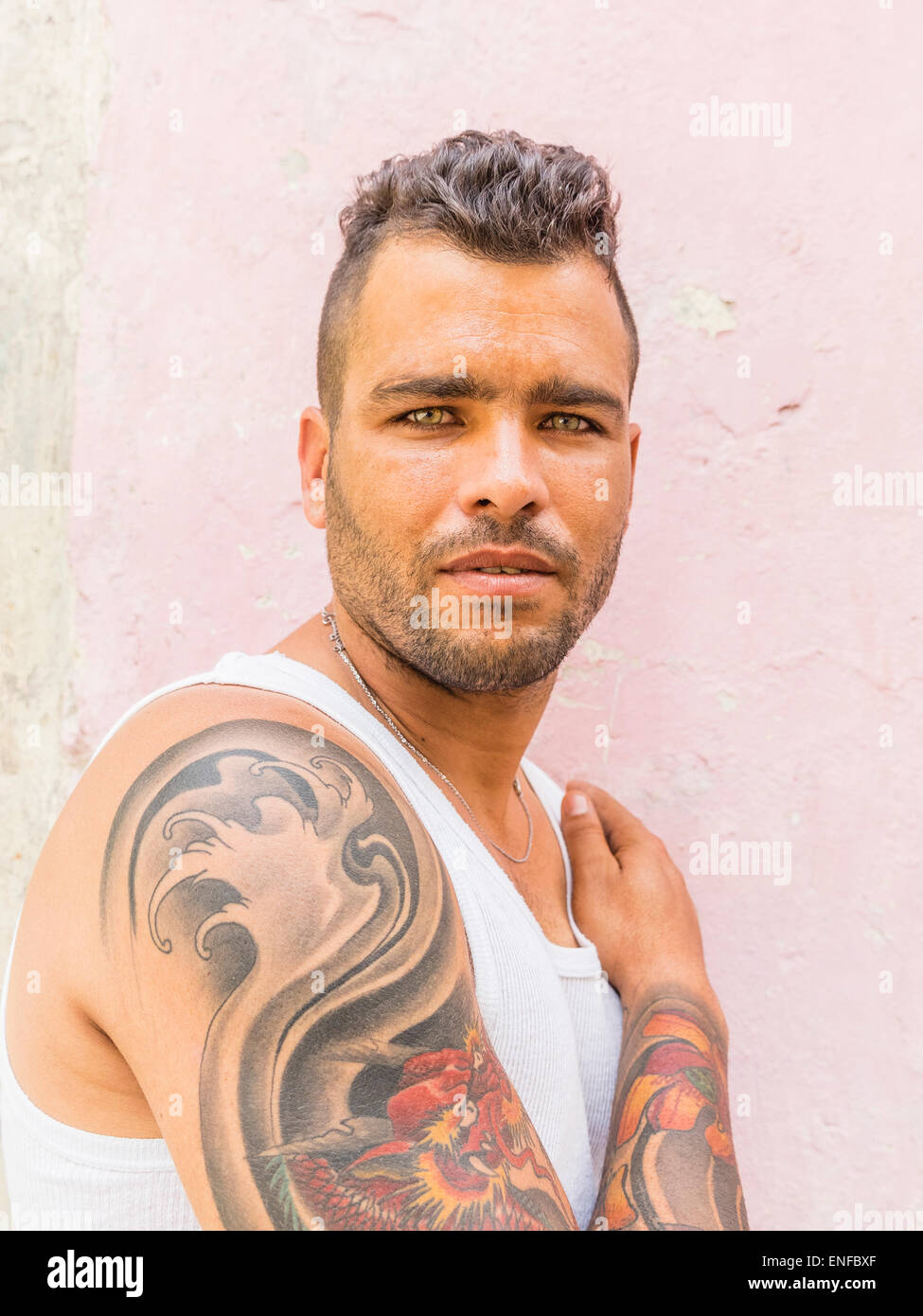 A 20-29 year old Cuban Hispanic male shows off his tattooed upper arm in Havana Vieja. Stock Photo
