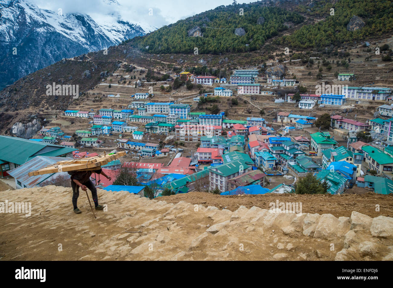 Namche Bazaar, Nepal - 9 March 2015: View of a a Nepalese porter carrying a heavy load Stock Photo
