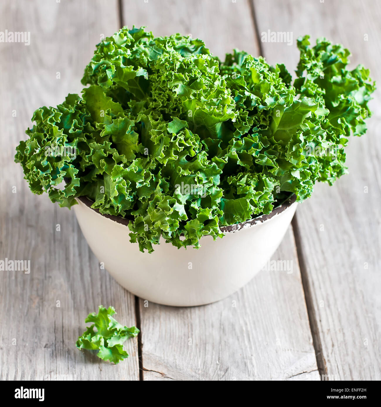 Fresh green kale in ceramic bowl. Selective focus. Stock Photo