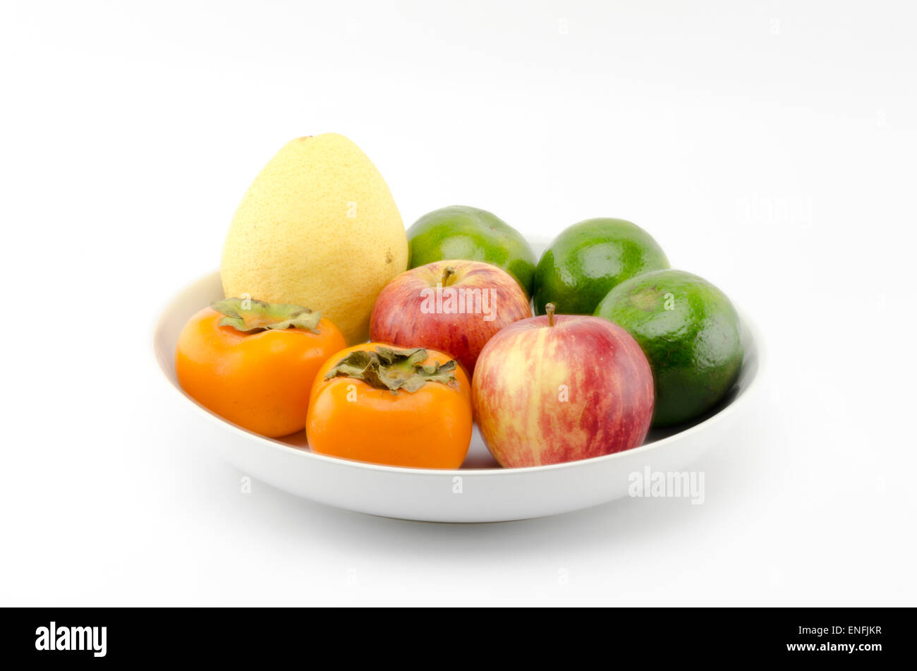 chinese pear apple green orange and persimon on white dish isolated on white background Stock Photo