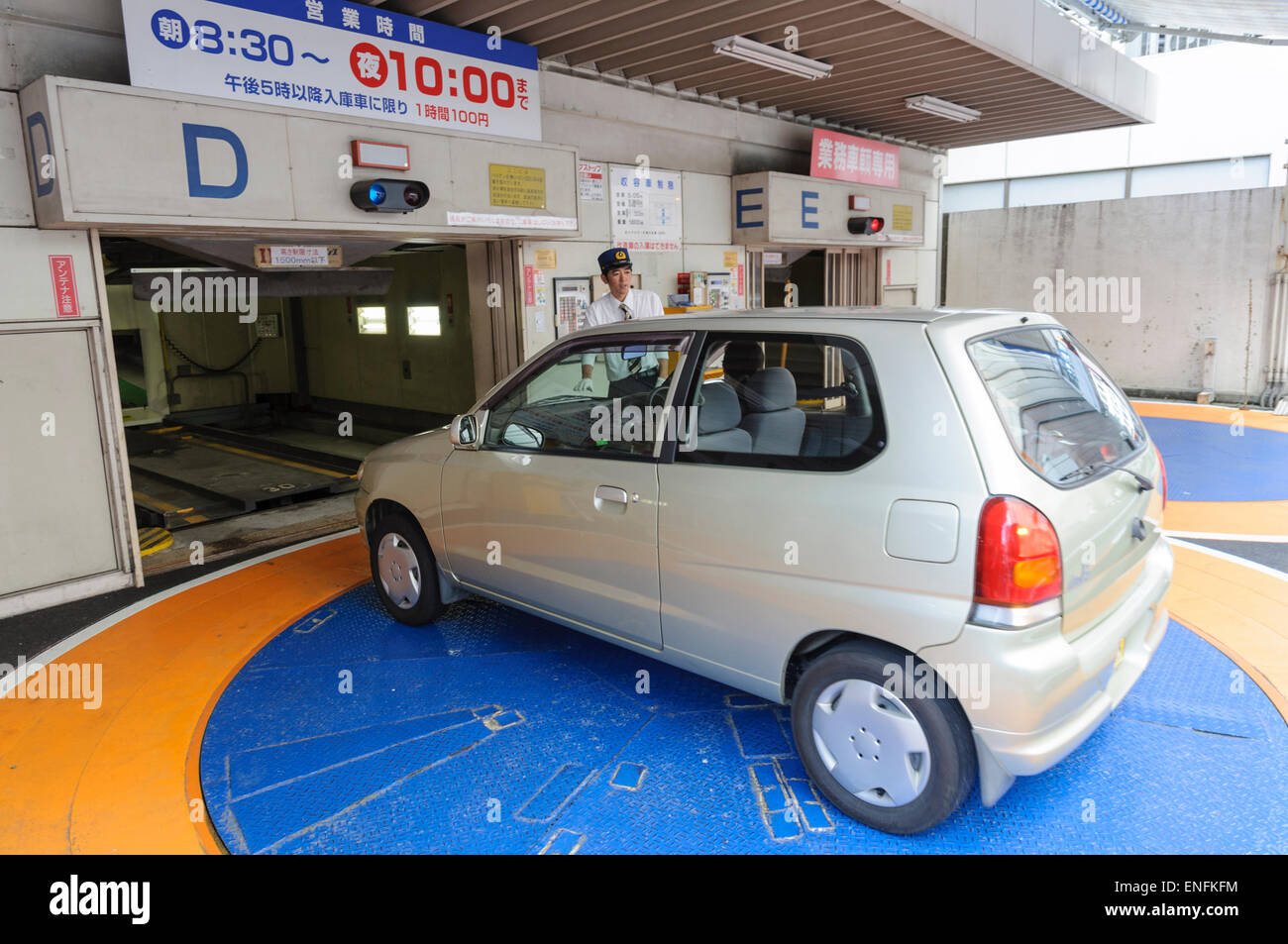 Small Japanese car on a turntable, entering an automatic, vertical car park. Car park; car parking; kei car; kei jidosha; Japan; very small car Stock Photo