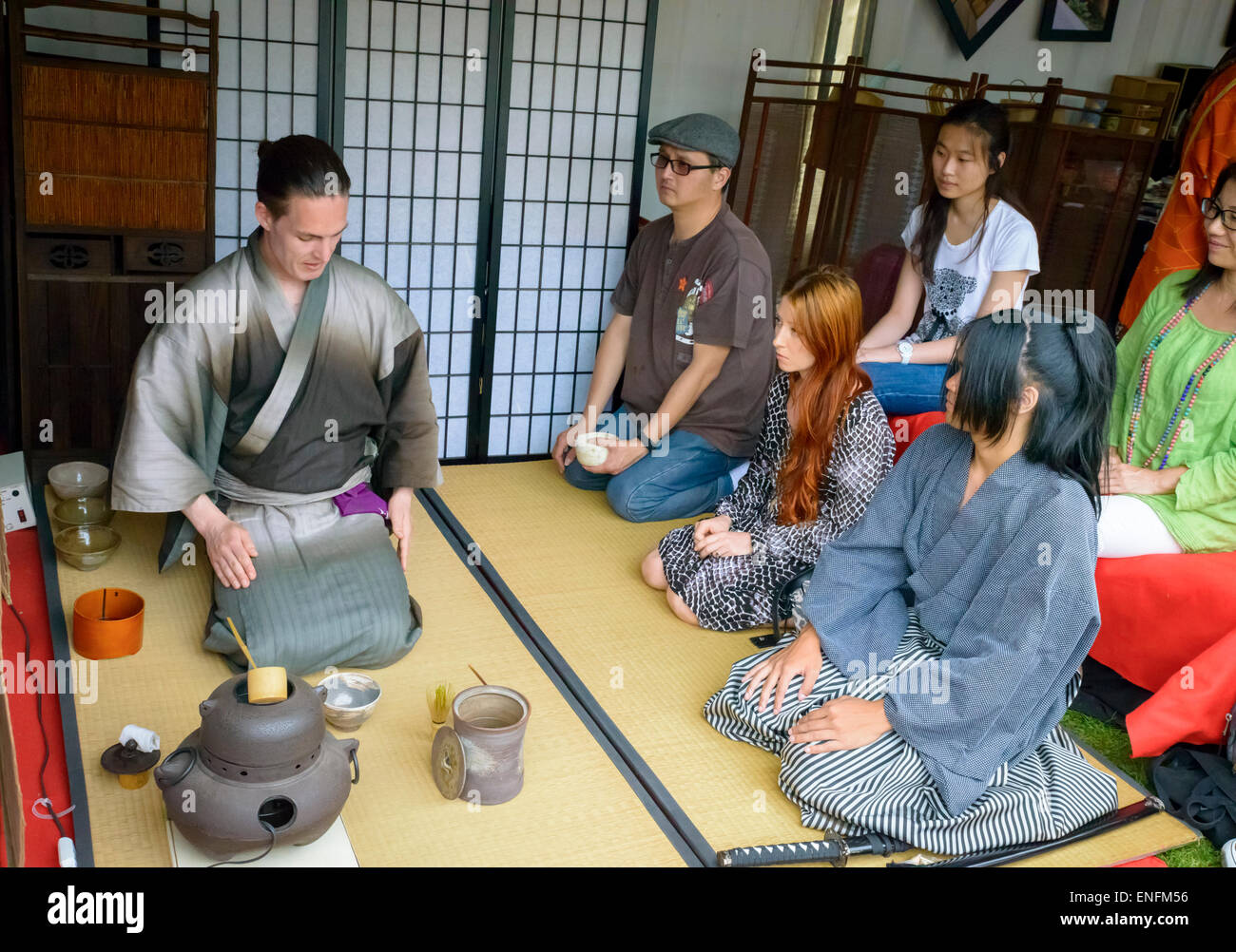 Tea ceremony demonstration, on tatami mats and with traditional equipment used for cha-no-yu. Traditional costumes, male kimono. Mixed race people. Stock Photo
