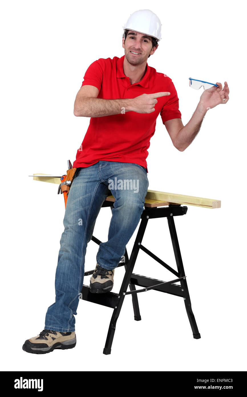 portrait of high-spirited carpenter showing protective goggles Stock Photo