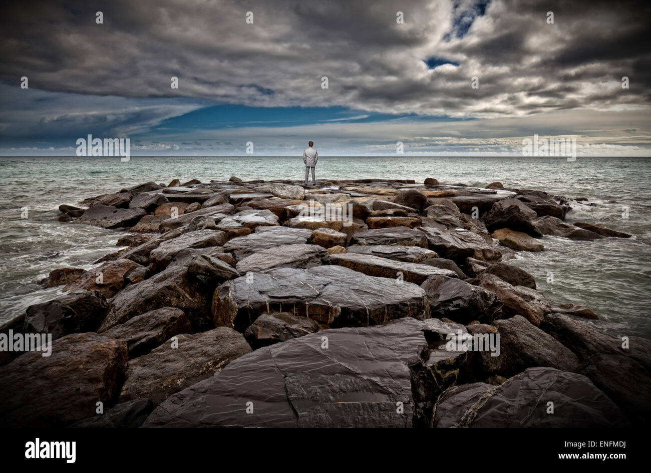 standing businessman on sea rock Stock Photo