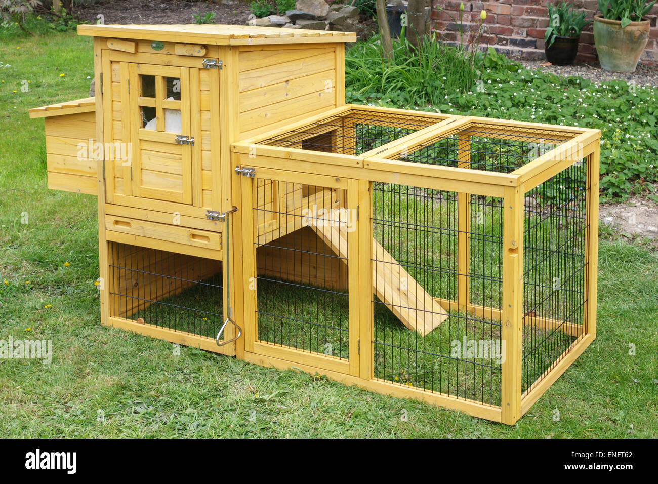 UK. A small wooden hen coop and wire chicken run, suitable for use in a town garden or urban location Stock Photo