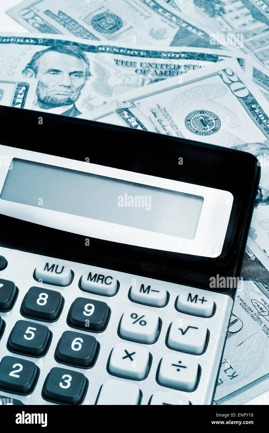 an electronic calculator on a pile of dollar bills, under business and finance concept Stock Photo