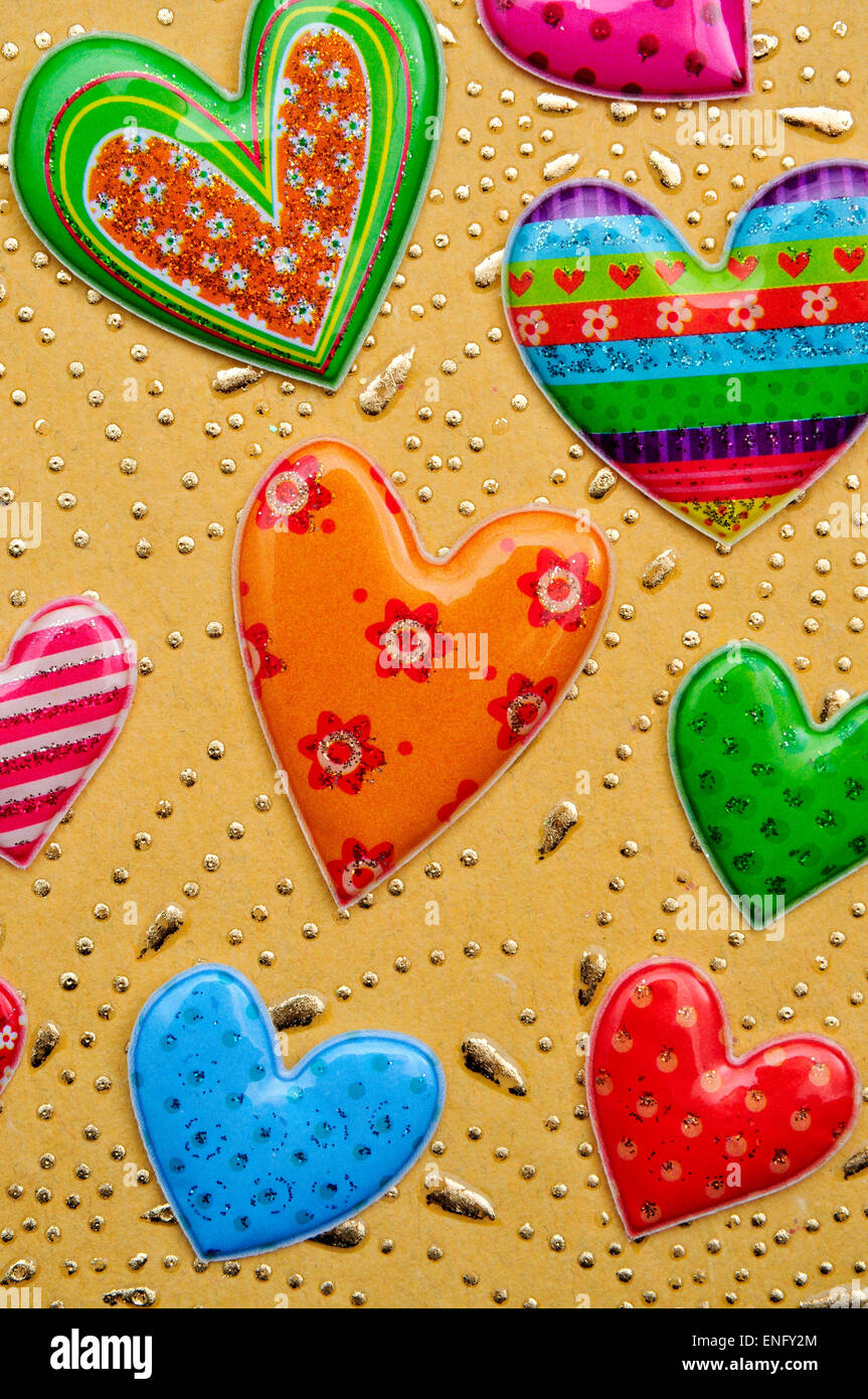 a pile of different patterned hearts on a beige and golden textured ...