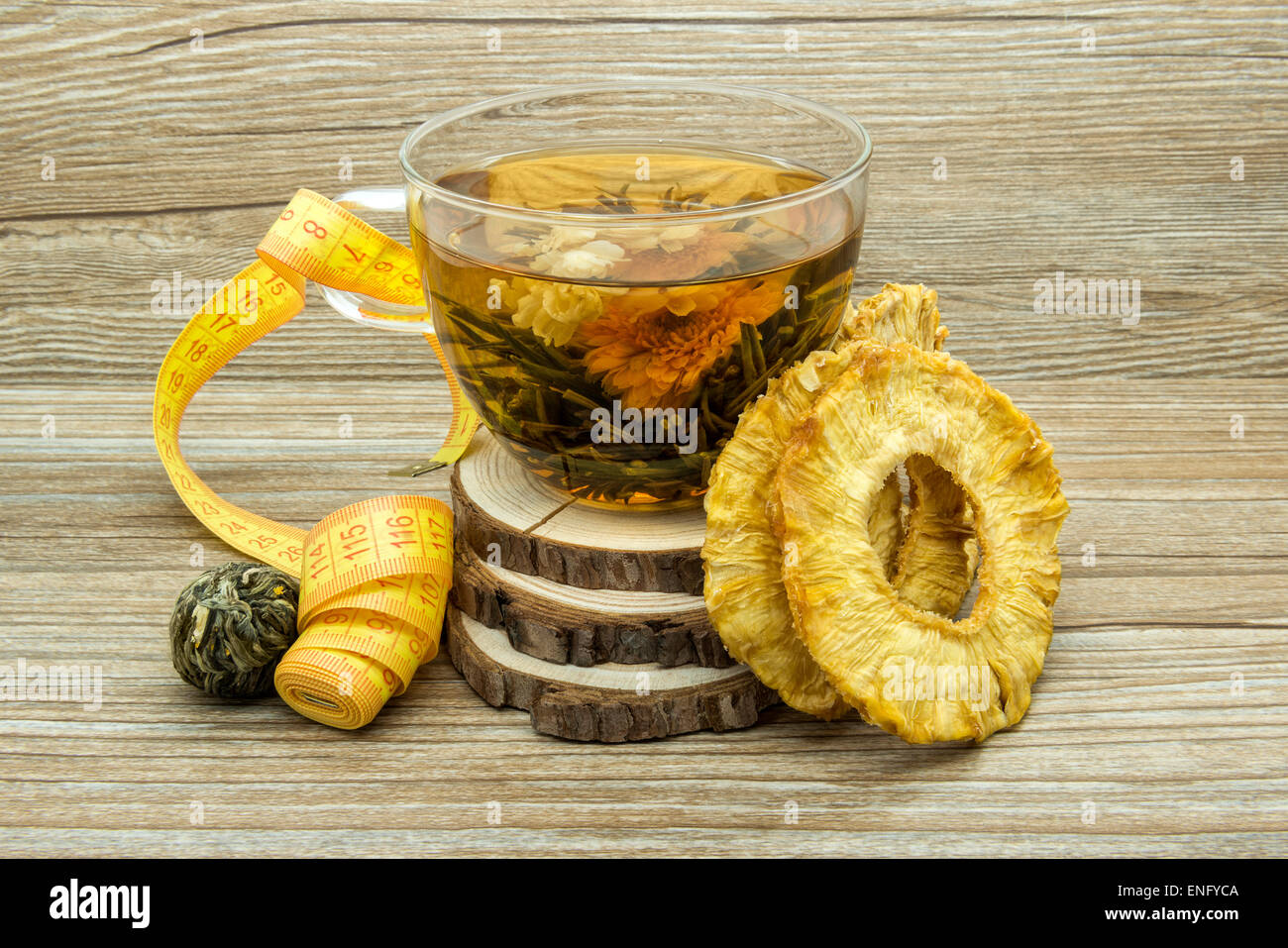 Dietary jasmine tea and dried pineapple on a wooden background. Stock Photo