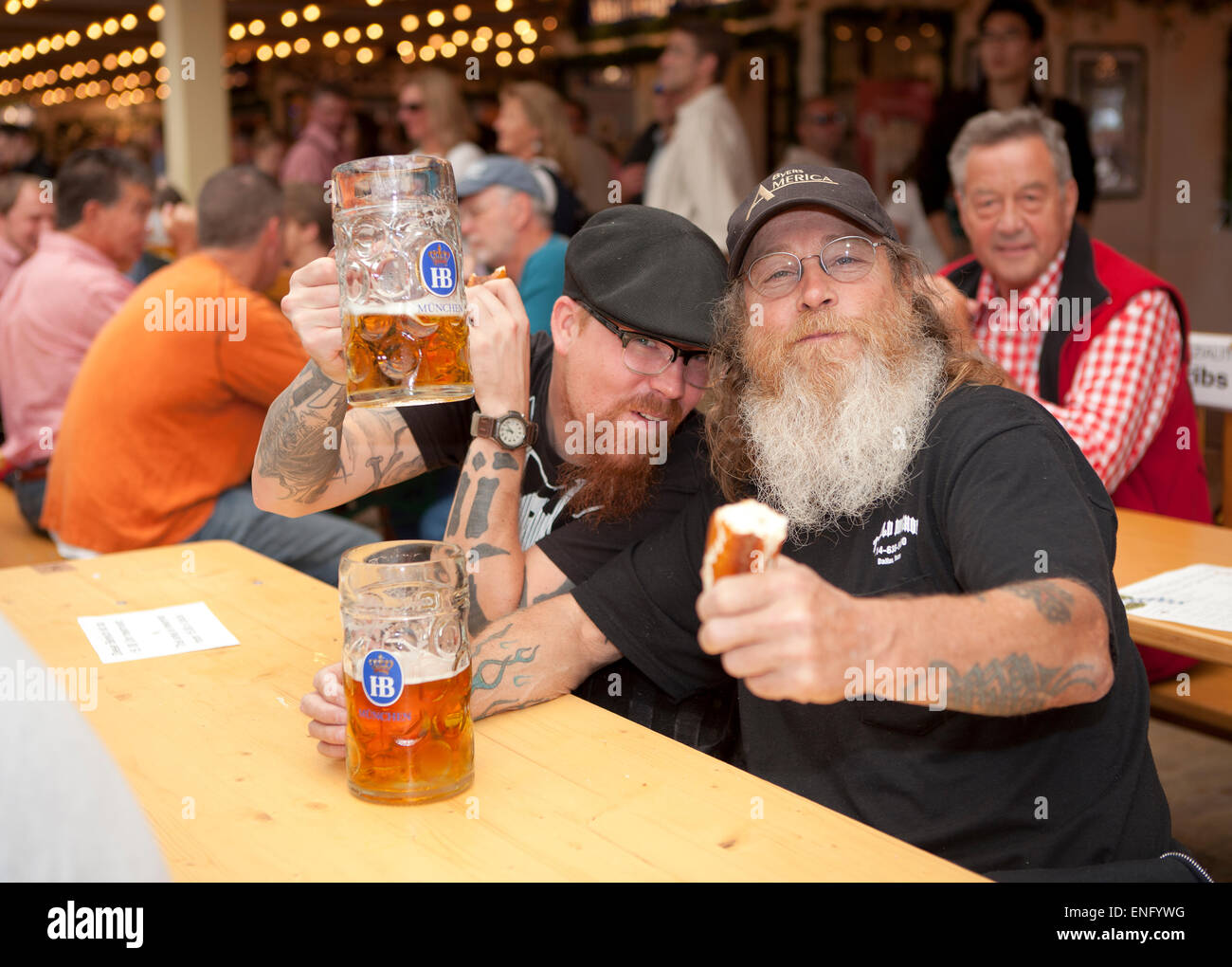 Visitors sit in the beer tent at the Oktoberfest with a beer mug Stock Photo
