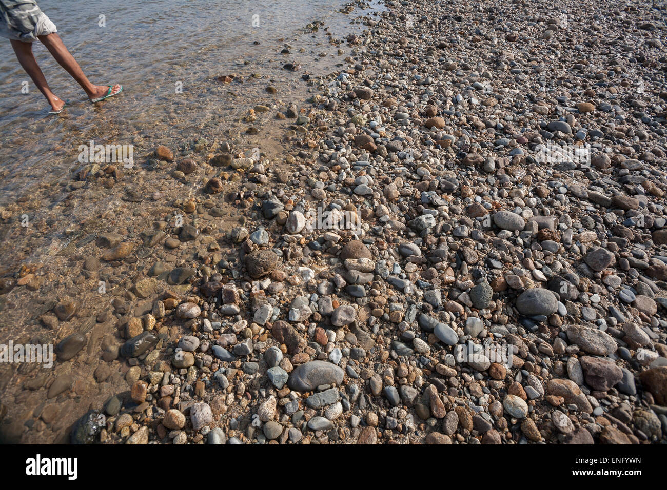 A man standing on a riverbed near Lubuk Sikaping, Pasaman, West Sumatra, Indonesia. Stock Photo