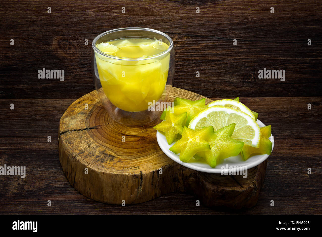 Pineapple juice and lemon with star fruit on a wooden background. Stock Photo