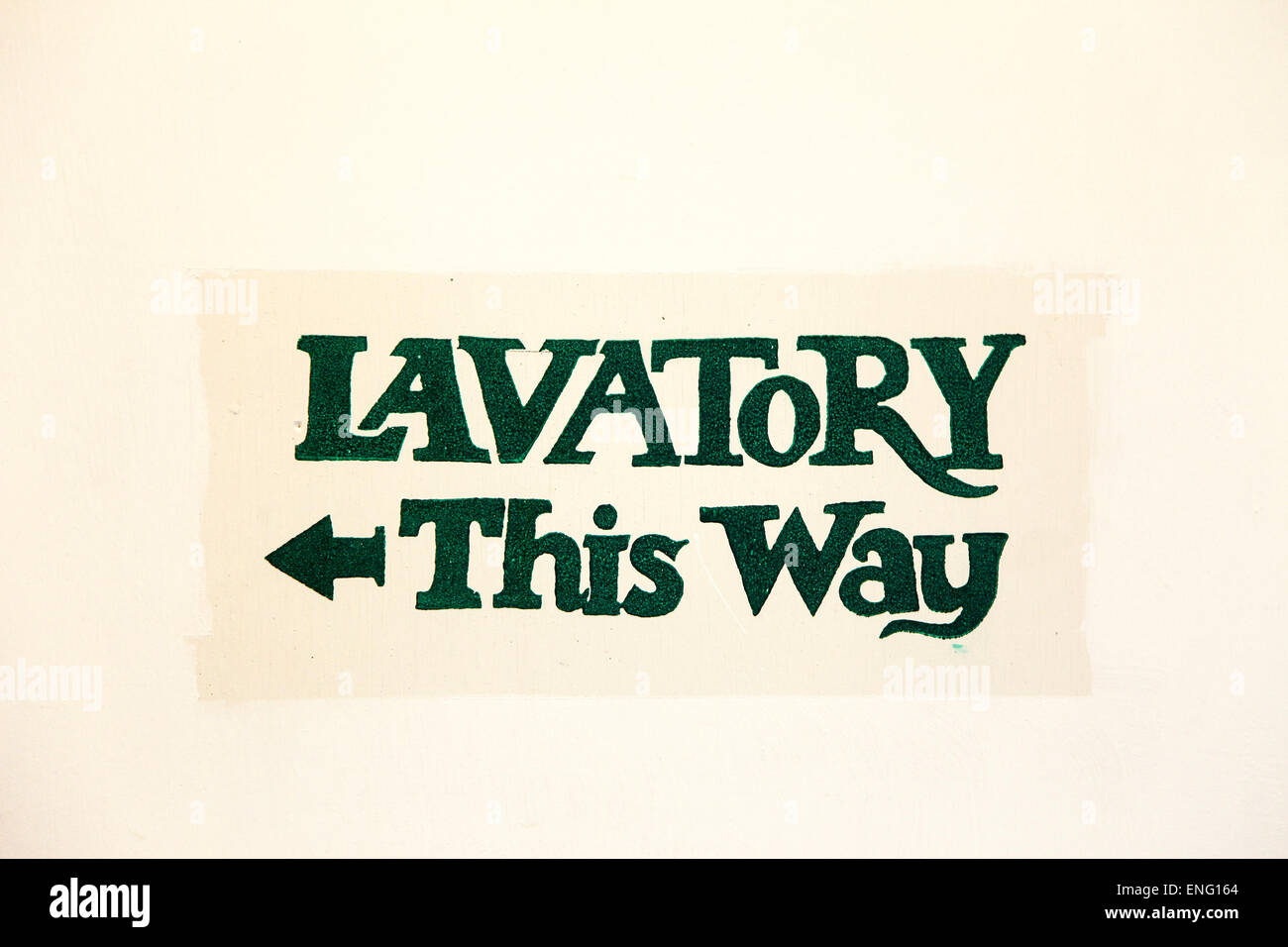 A painted sign on a wall saying lavatory this way Stock Photo