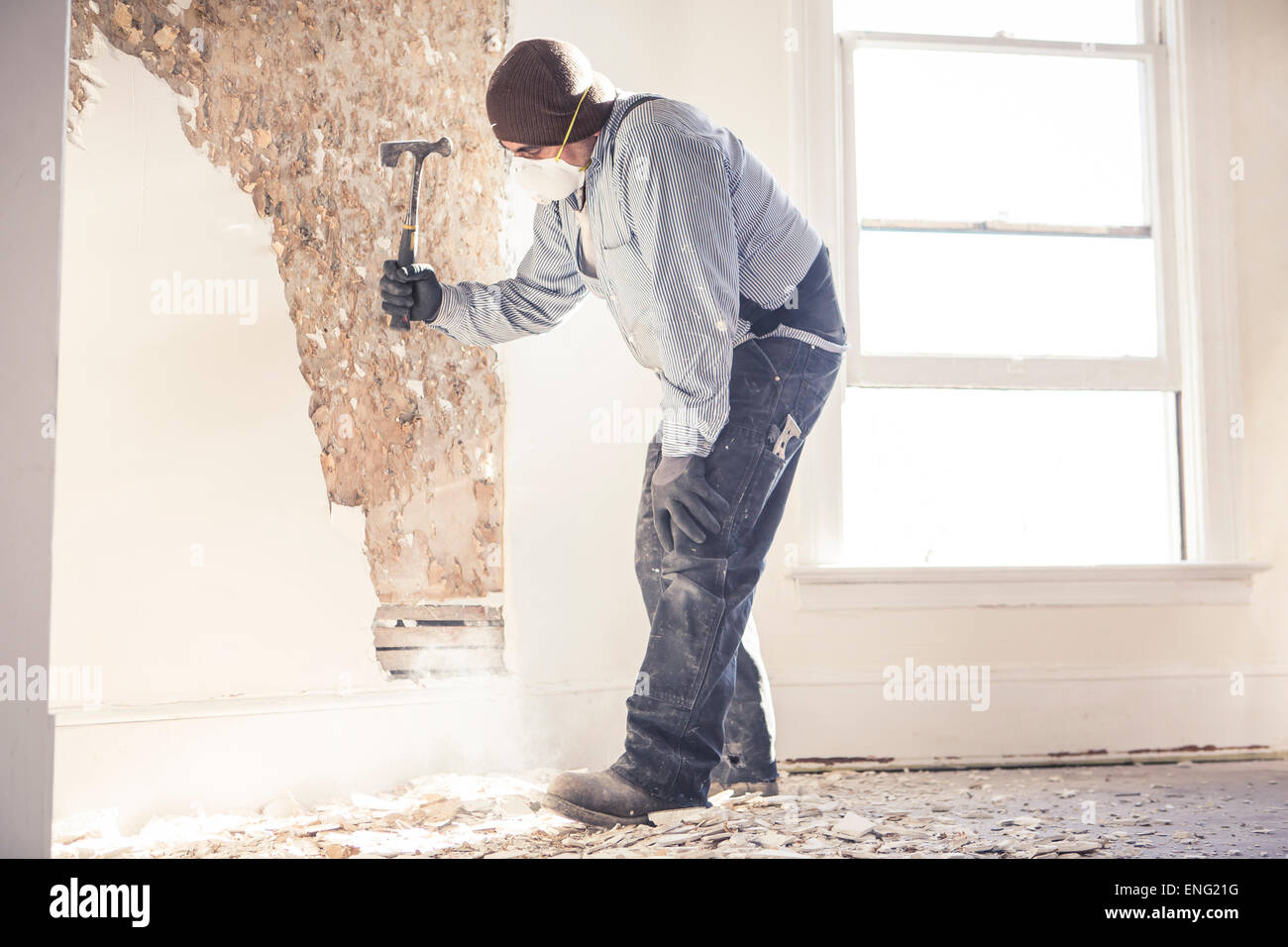 Hispanic construction worker hammering wall Stock Photo