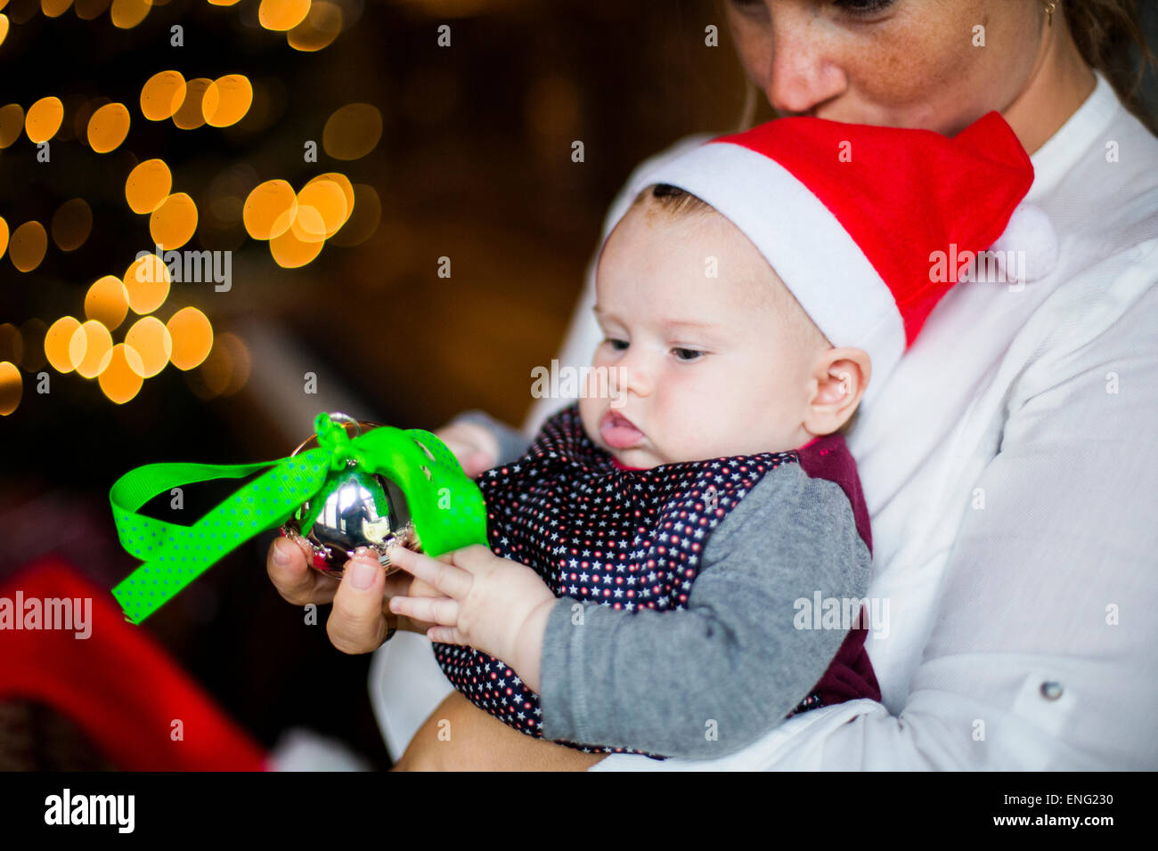 Close up of mother holding baby girl with Christmas ornament Stock Photo