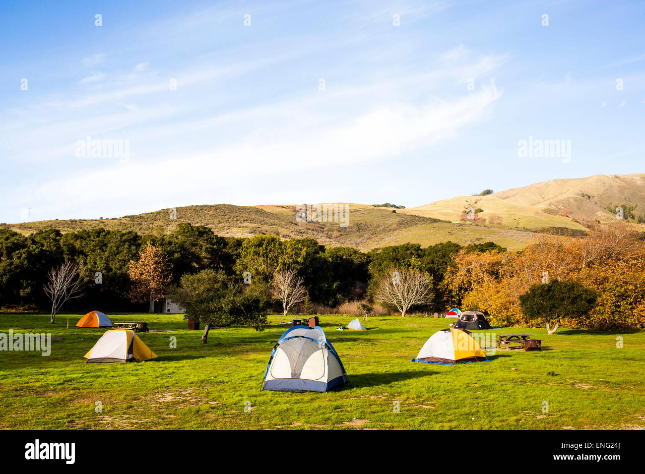 Camping tents in remote grassy field Stock Photo