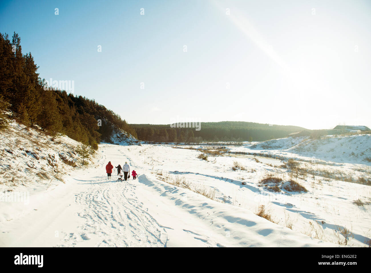Caucasian family cross-country skiing in snowy field Stock Photo