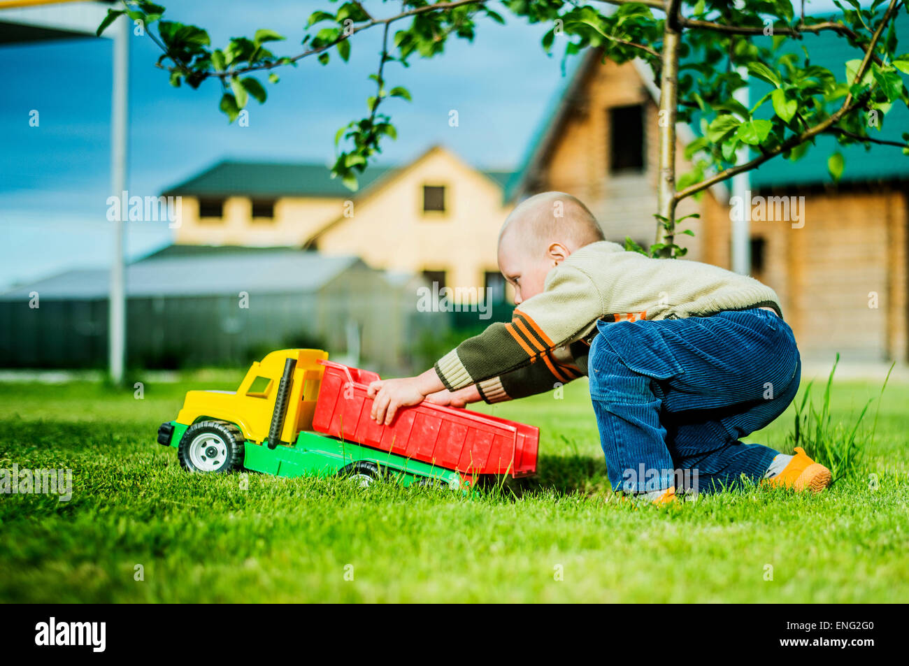 Caucasian boy playing with toy truck in backyard Stock Photo