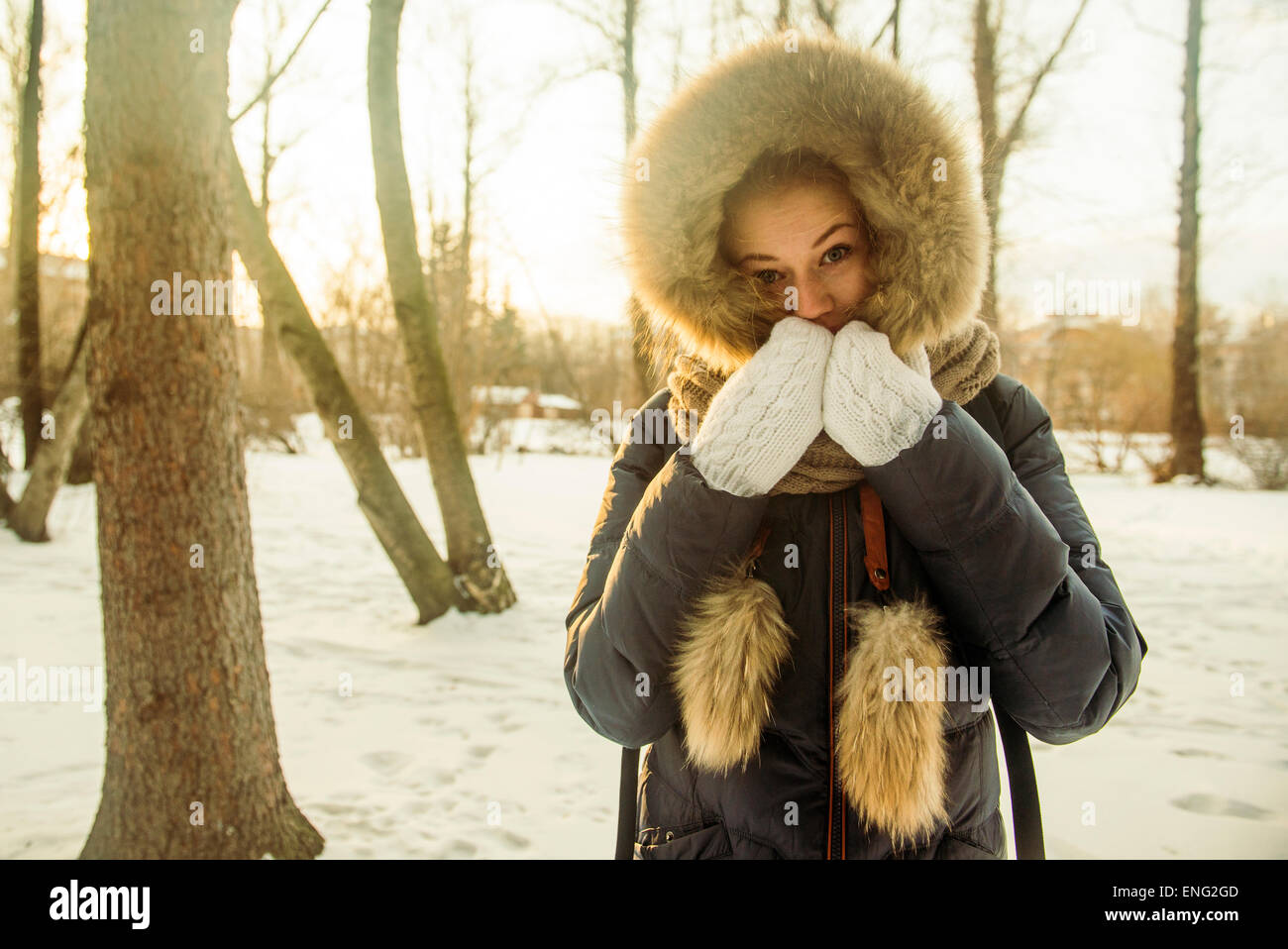 Caucasian woman wearing fur hood and coat in snowy field Stock Photo