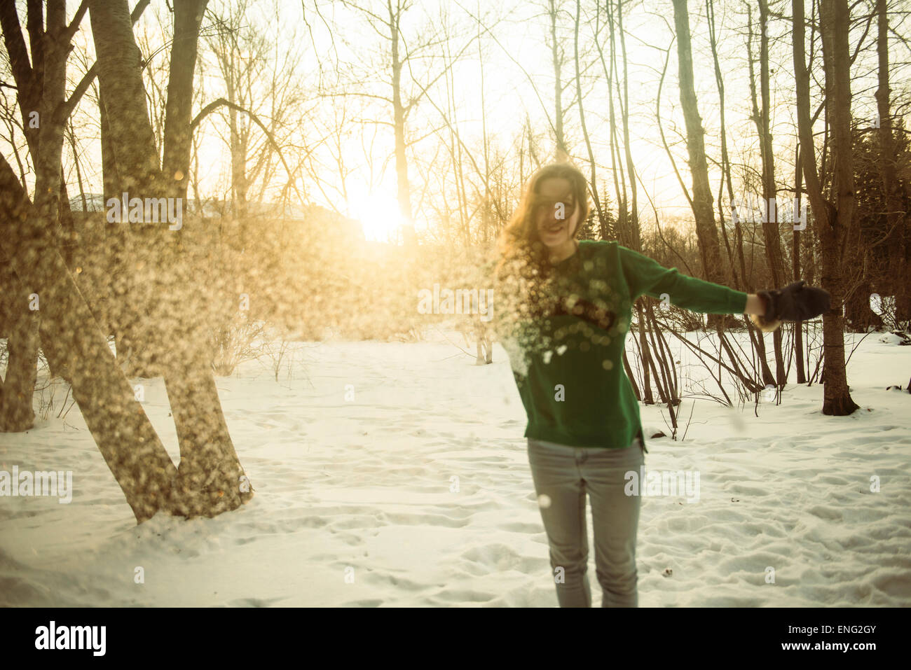 Caucasian woman playing in snowy field Stock Photo