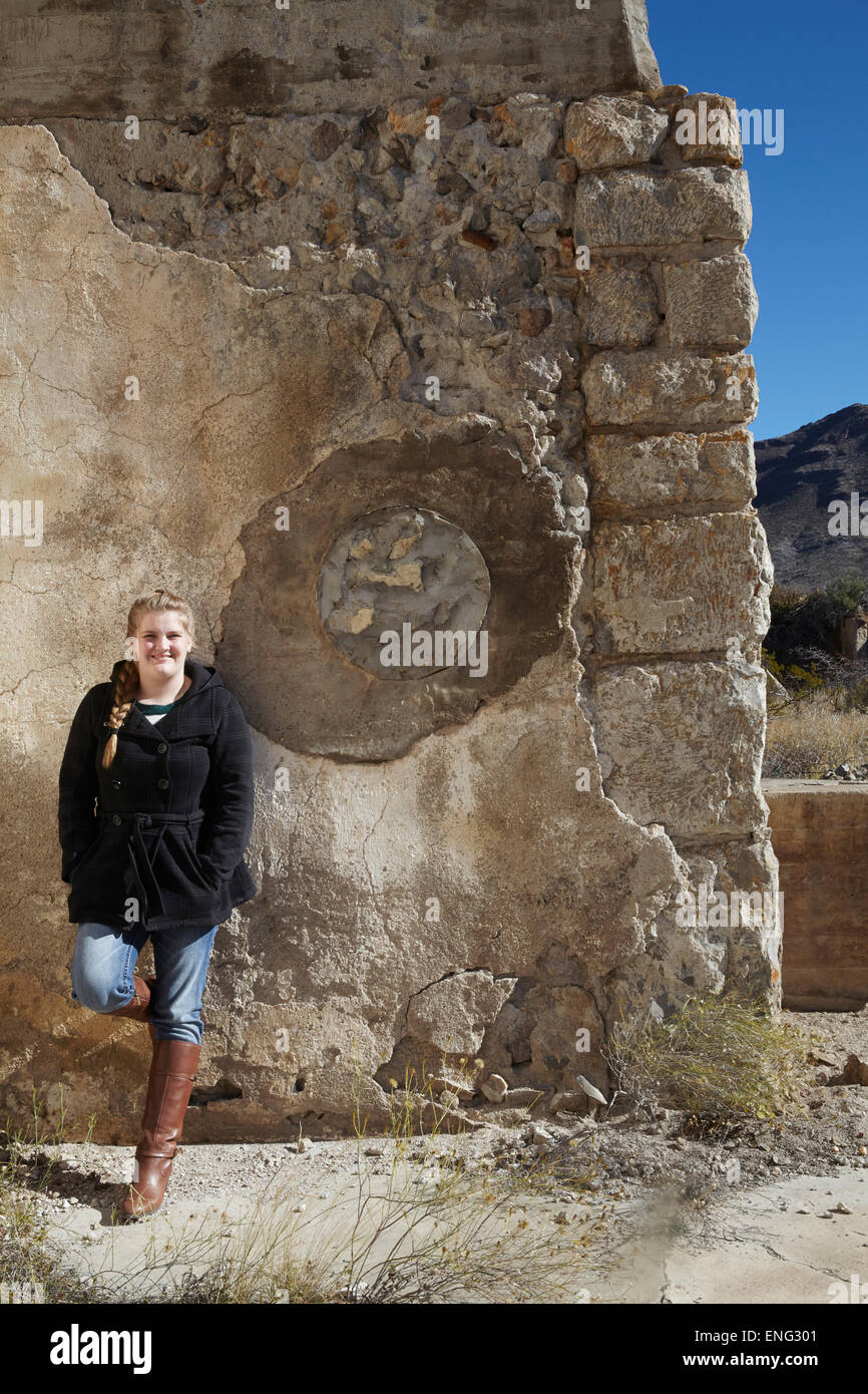 Tourist smiling near relief sculpture on wall of ruins Stock Photo
