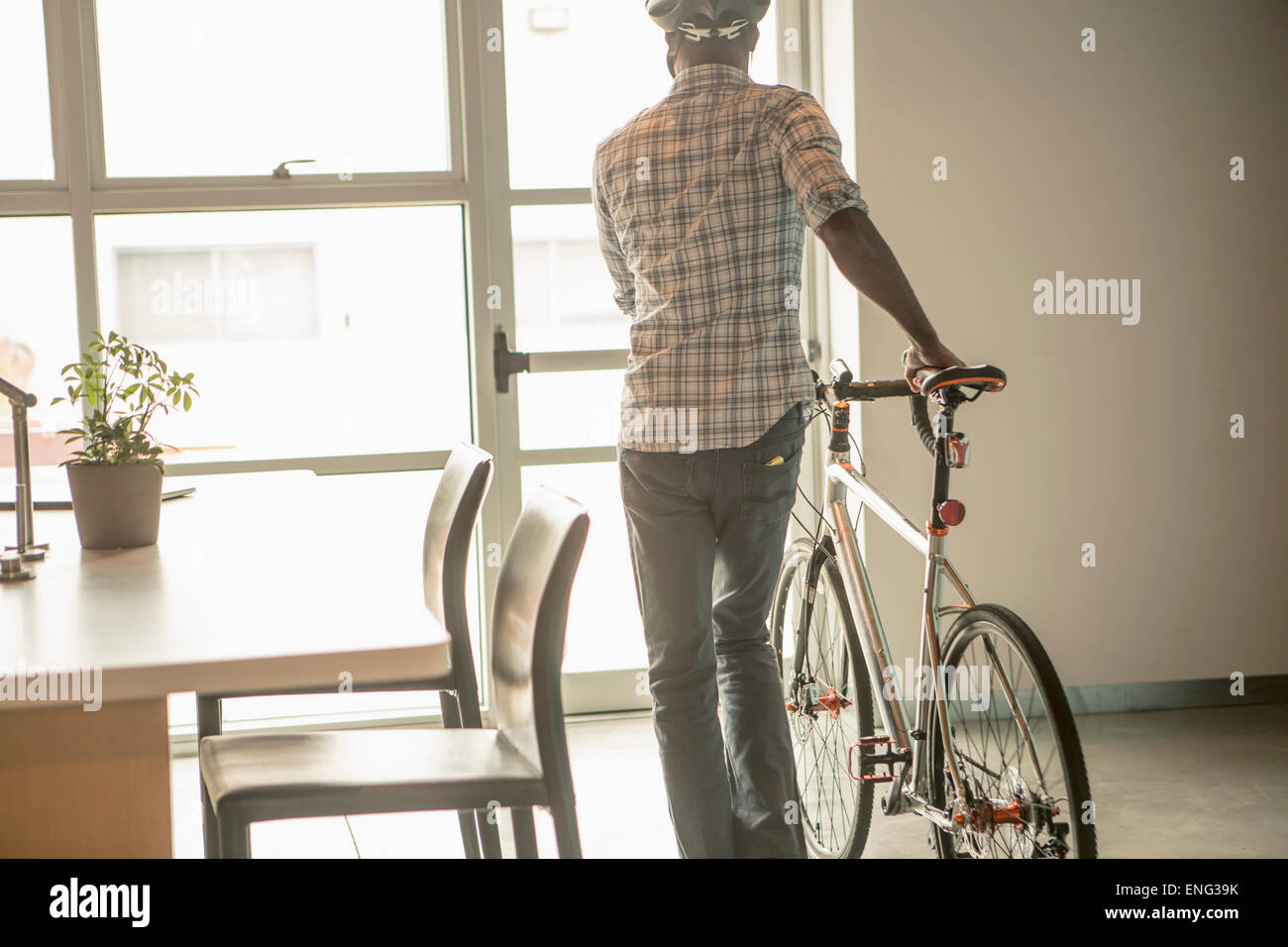 Black businessman leaving office with bicycle Stock Photo