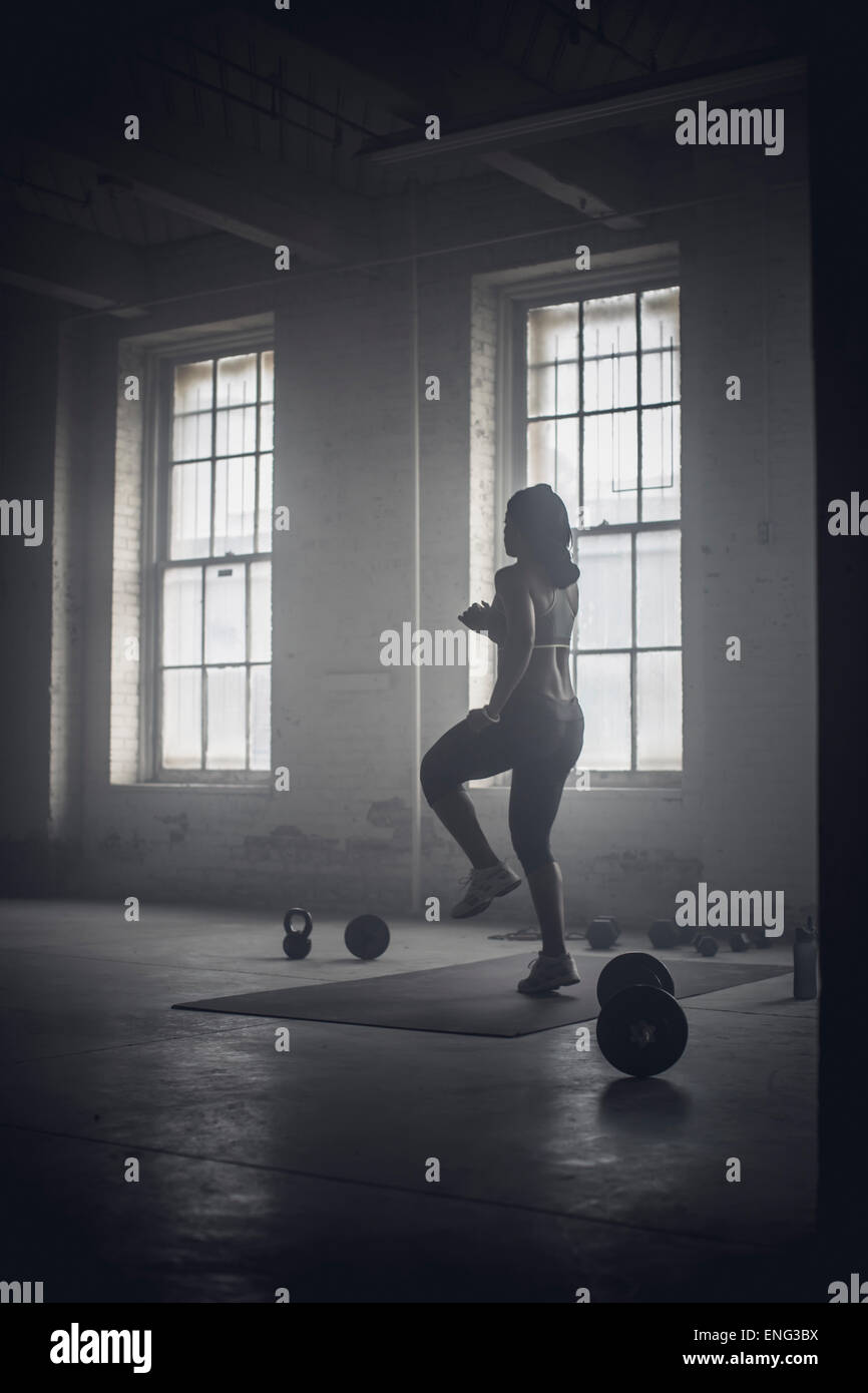 Black woman exercising in dark gym Stock Photo