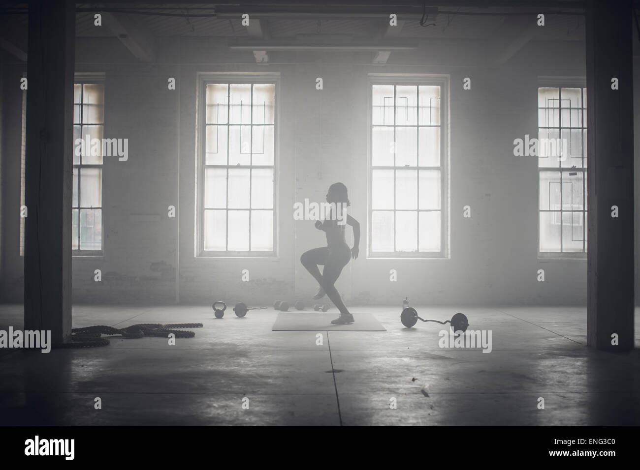 Black woman exercising in dark gym Stock Photo
