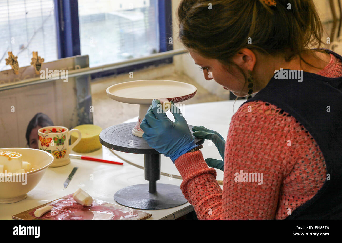 A woman potter decorating a cake stand by hand at the Emma Bridgewater