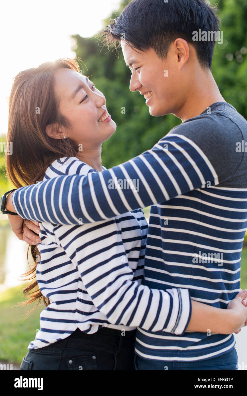 Smiling Korean couple hugging in park Stock Photo - Alamy