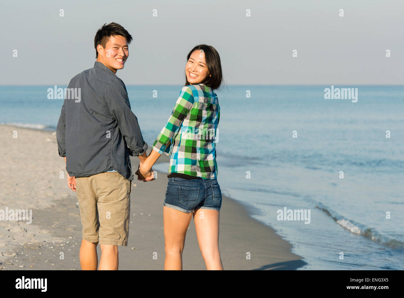 Korean couple walking on beach Stock Photo