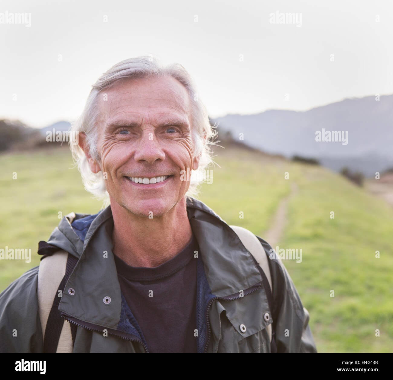 Older Caucasian man walking on dirt trail Stock Photo