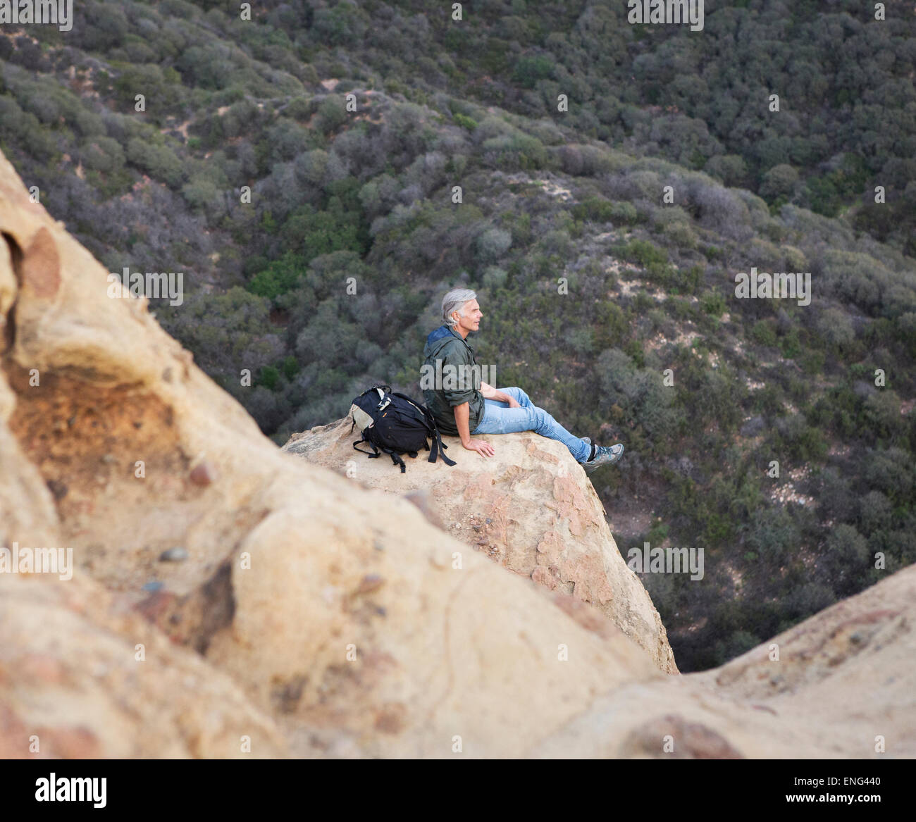 Person sitting on rock hi-res stock photography and images - Alamy