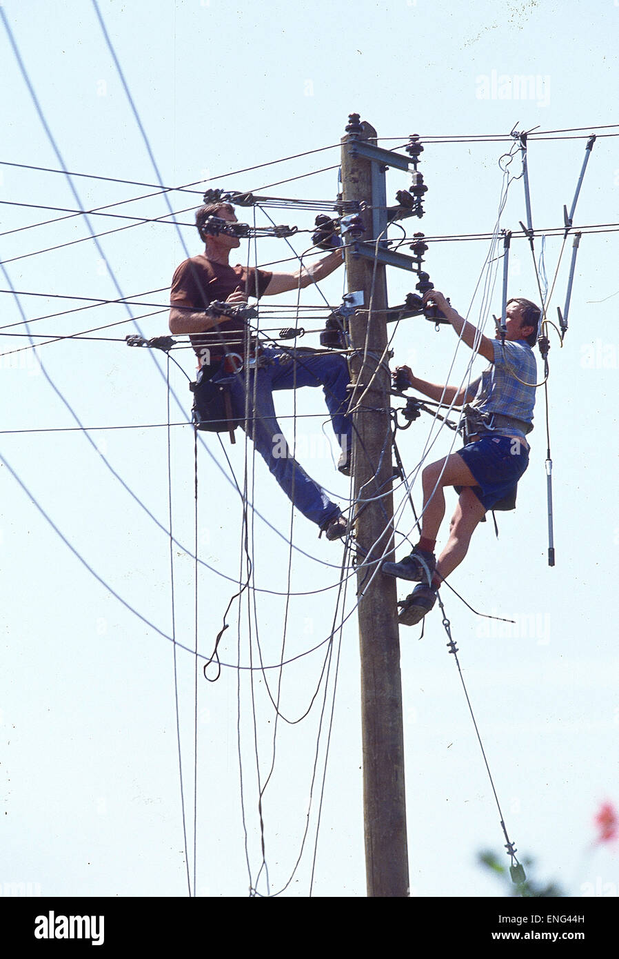 Zwei Arbeiter an Telegrafenmast Stock Photo