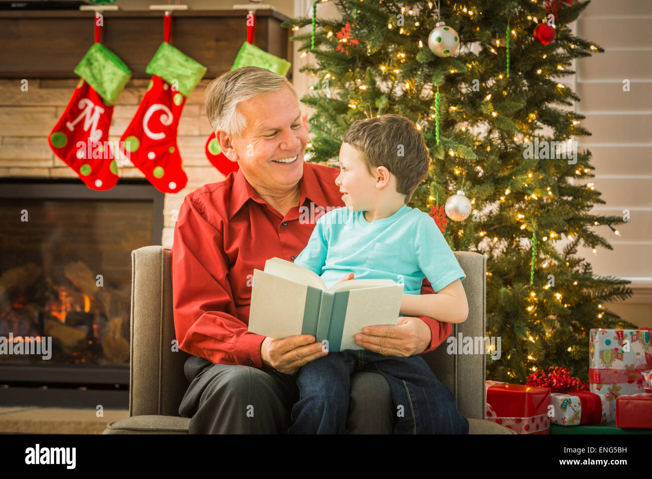 Caucasian grandfather reading to grandson at Christmas Stock Photo