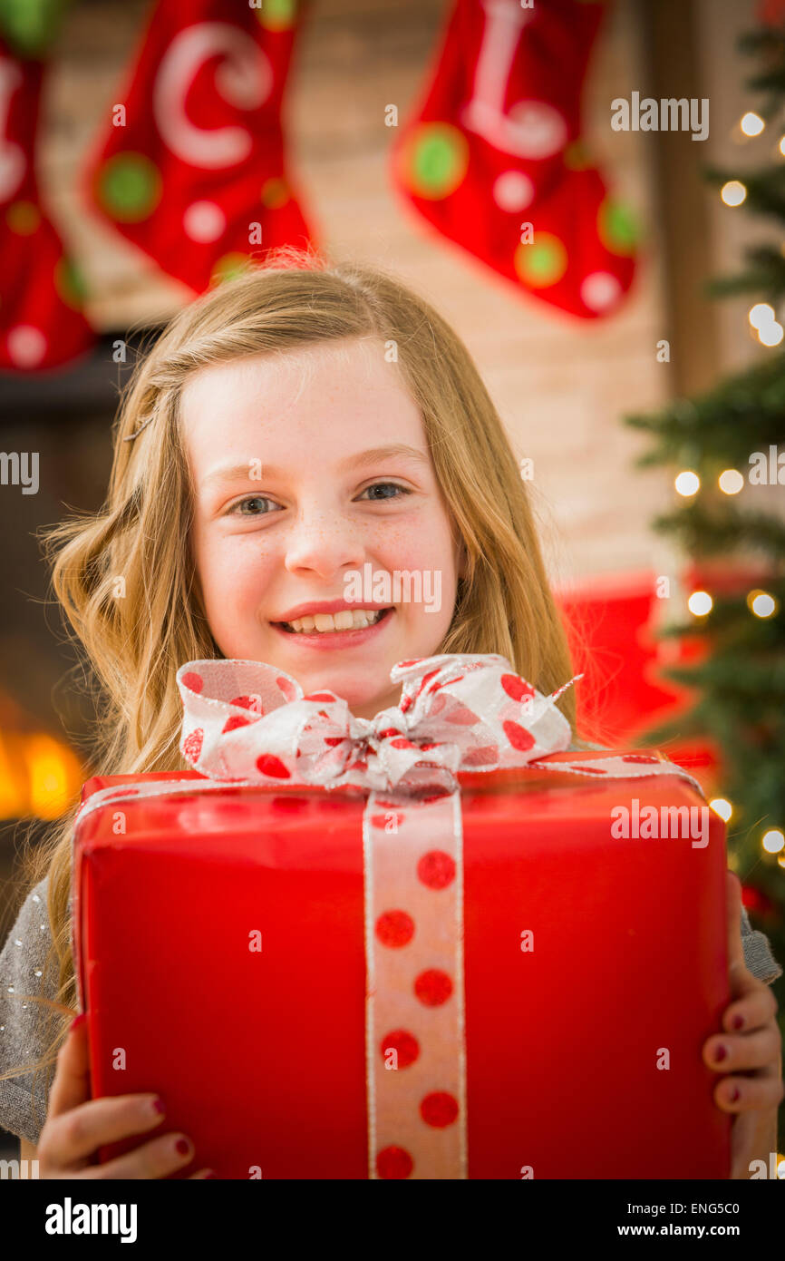 Caucasian girl holding Christmas gift Stock Photo