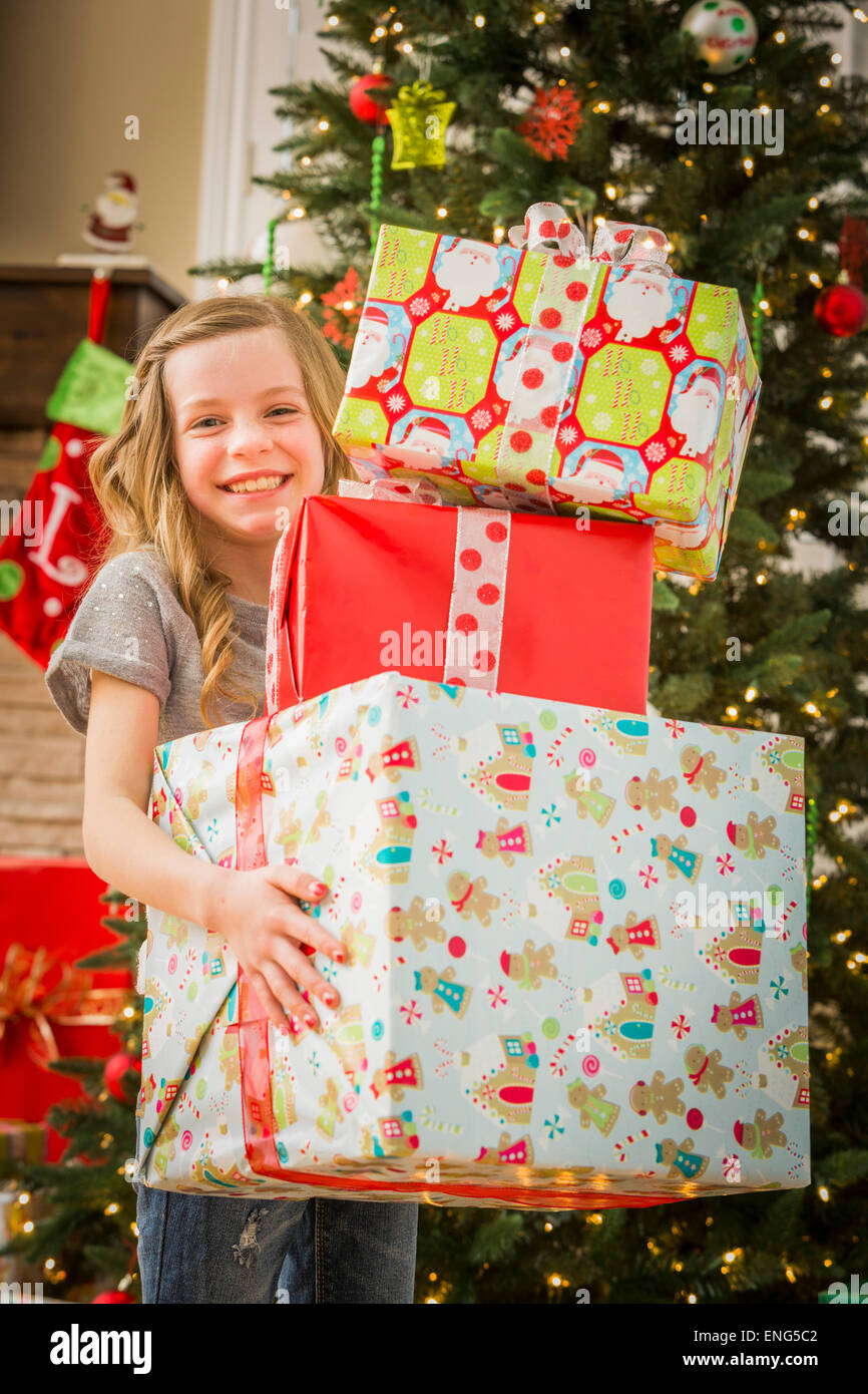 Caucasian girl holding pile of Christmas gifts Stock Photo