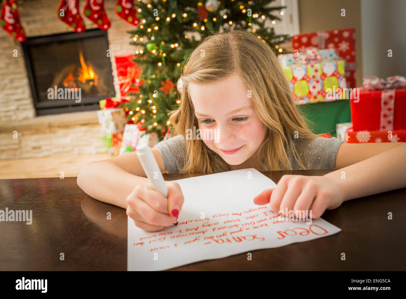 Caucasian girl writing to Santa at Christmas Stock Photo