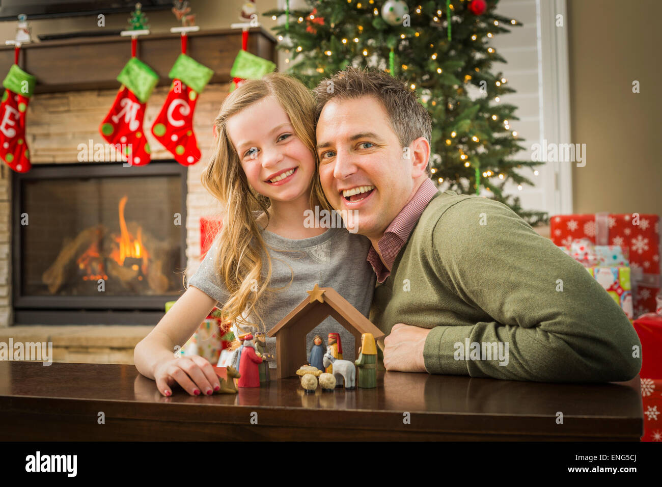 Caucasian father and daughter arranging nativity at Christmas Stock Photo