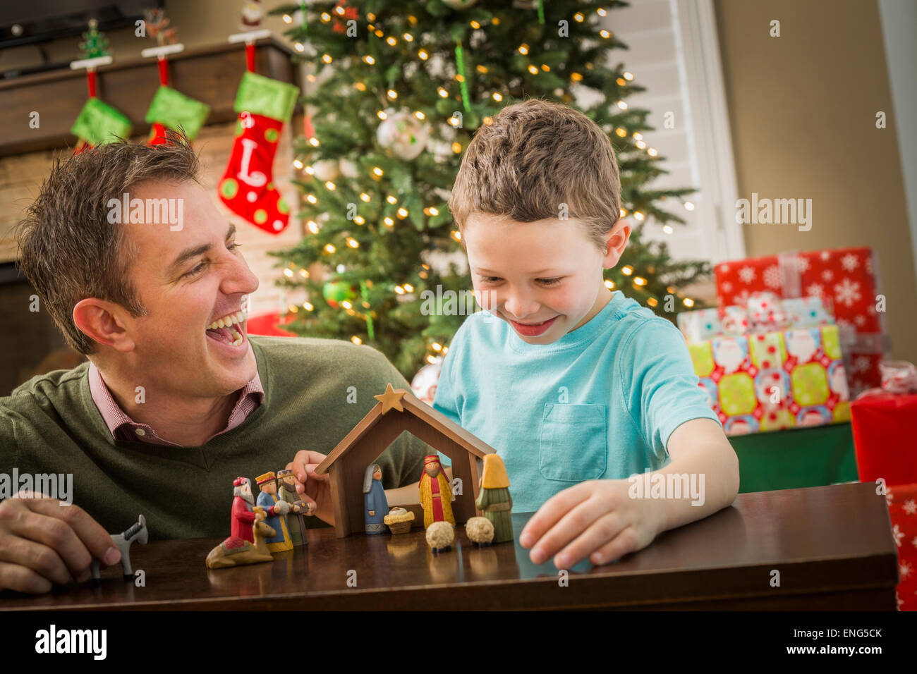 Caucasian father and son arranging nativity at Christmas Stock Photo