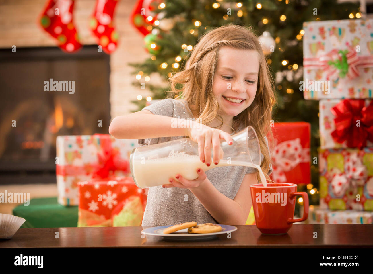 Caucasian girl leaving cookies and milk for Santa at Christmas Stock