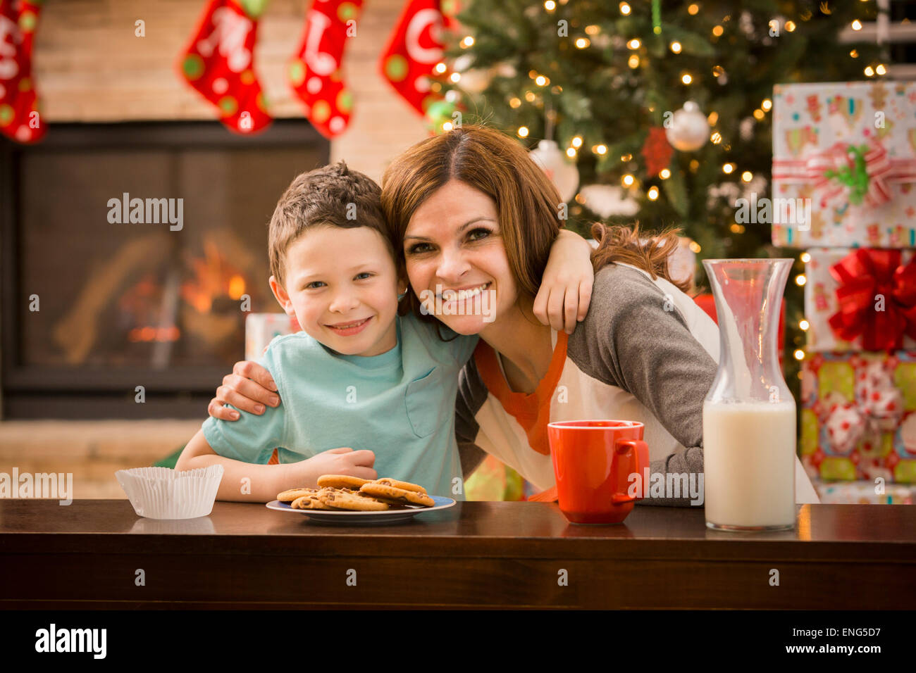 Caucasian mother and son leaving cookies and milk for Santa at Christmas Stock Photo