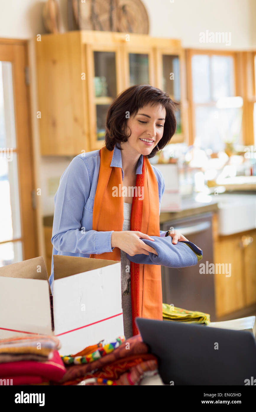 Hispanic business owner packing boxes in home office Stock Photo