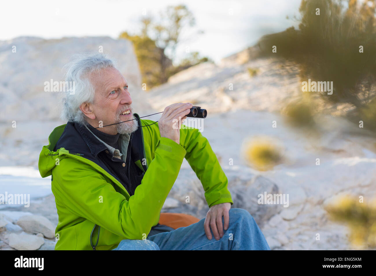 Older man admiring view with binoculars Stock Photo